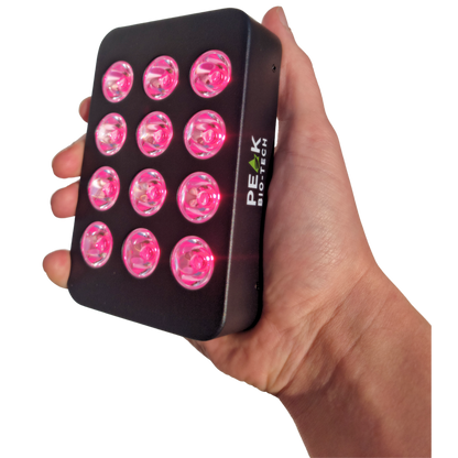 Peak Bio-Tech Peak Mini 60W portable clinical-grade red light therapy panel held in hand, showcasing its compact size and operating LEDs
