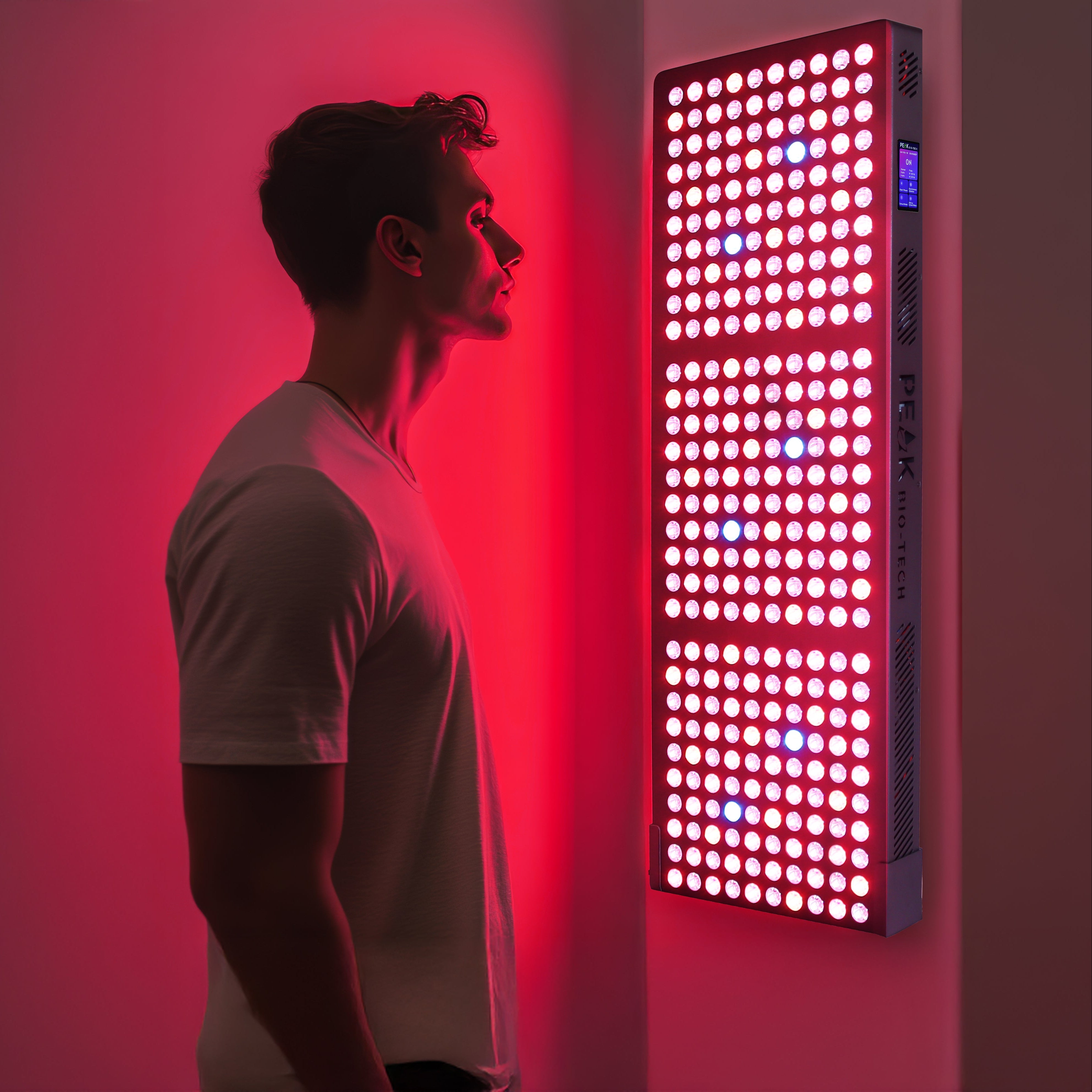 Person standing in front of the Peak Bio-Tech Peak Radiance Pro 1500W Red Light Therapy Panel with IR and NIR LEDs turned on, promoting muscle recovery, pain relief, and skin rejuvenation.